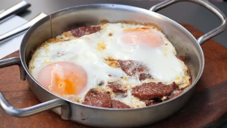 huevos fritos con carne en una sartén