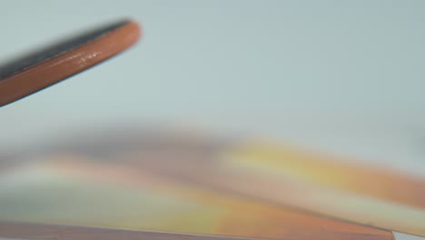 a hyper close-up macro detailed shot of a mini skateboard, tiny white wheels, riding fingerboard from left to right, finger slide, professional lighting, static cinematic 4k video