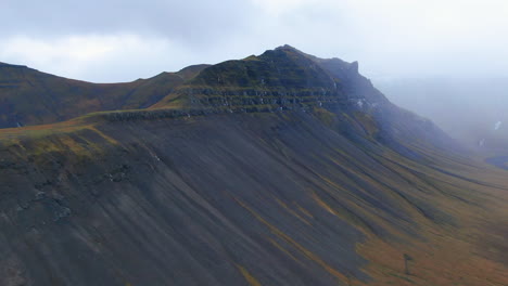 vista de avión no tripulado, zoom en vista de las montañas, acantilados y terreno rocoso en un día nublado en irlanda
