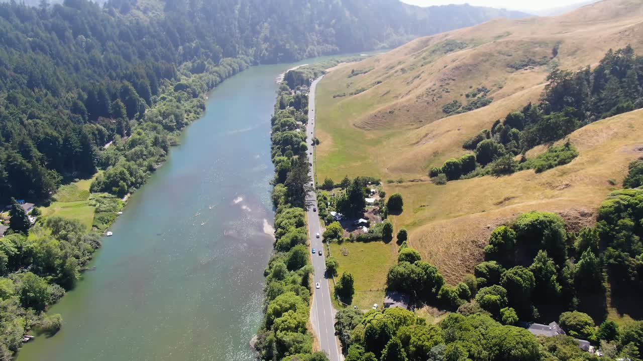 video aéreo de un paisaje rural con un canal fluvial en el medio, rodeado de vegetación y montañas en el horizonte en la bahía de bodega, costa de gualala en california