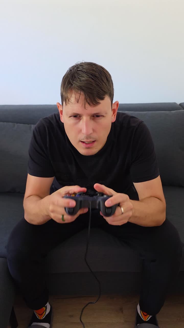 Vertical static of young man playing intense video game, serious expression on his face, frustrated gamer
