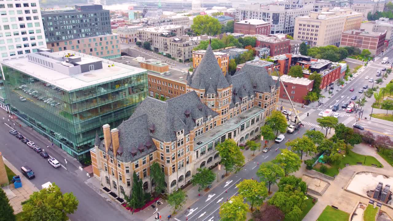 Downtown skyline with Hotel Viger and bustling streets, aerial descend and orbit