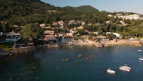 aerial dolly to coastal view homes with perfect window seating to look out on water and sunset in corfu greece