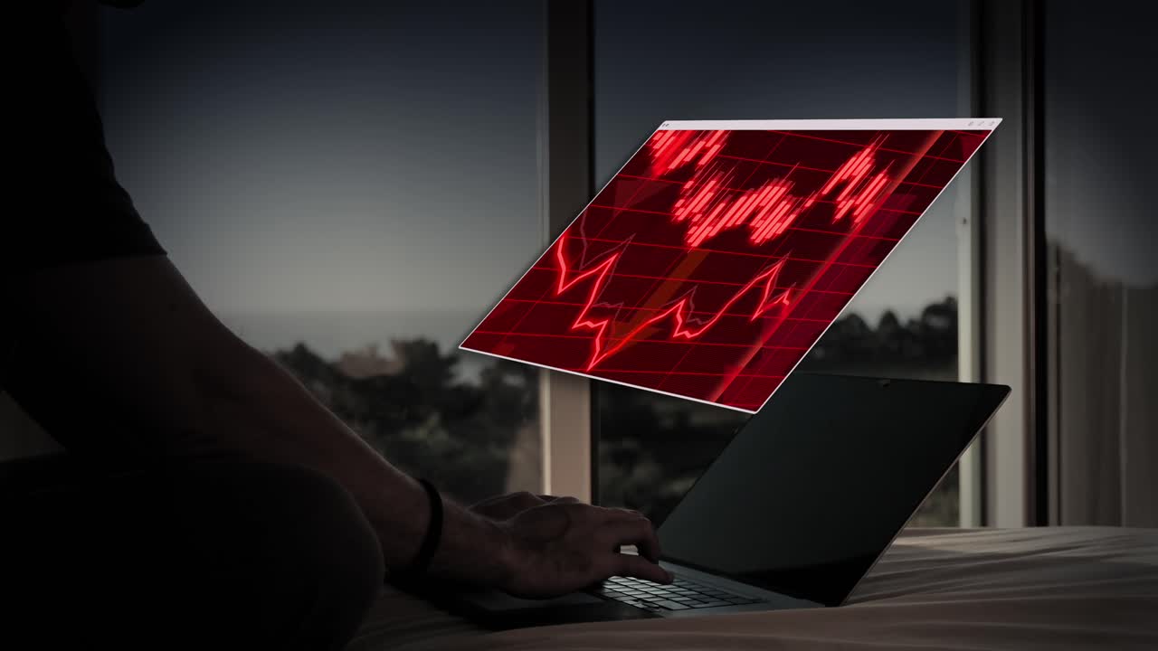 Red stock market crash graph displayed above a laptop
