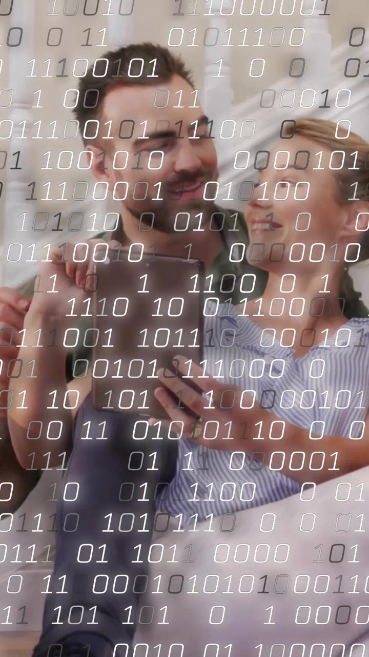 Vertical video: Woman tapping tablet, causing binary overlay growing over partners in tech demo