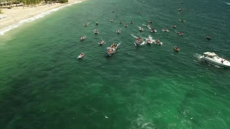 Toma-Aérea-De-La-Procesión-De-Un-Barco-En-El-Mar-Para-La-Virgen-María-En-Pampatar,-Isla-De-Margarita,-Venezuela