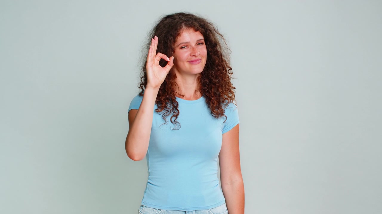 Woman smiling showing ok gesture approval satisfaction positive feedback happy pleased expression