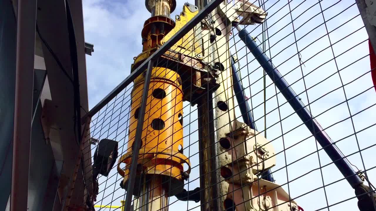 유압식 회전 굴착 장치가 올라가고 빙글빙글 돌 때 울타리를 통해 위를 바라보는 광각