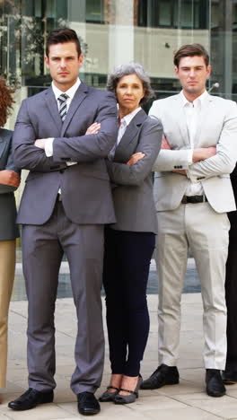 business people standing with arms crossed in office building