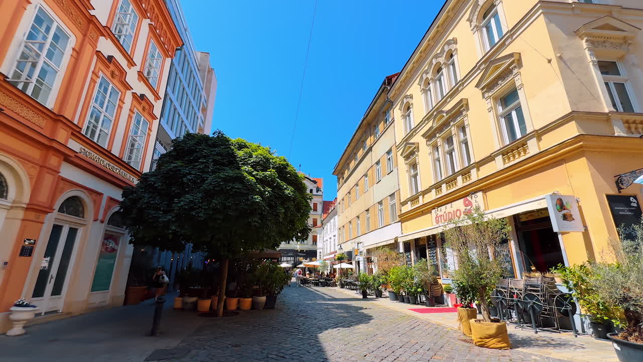 Bratislava, Slovakia, 2 June 2025: Charming streets of Bratislava. Cobblestone streets in Bratislava feature vibrant buildings and outdoor cafes under a clear blue sky on a sunny day