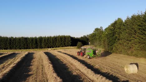 tractor presionando balas de heno en bélgica, filmado por un avión no tripulado