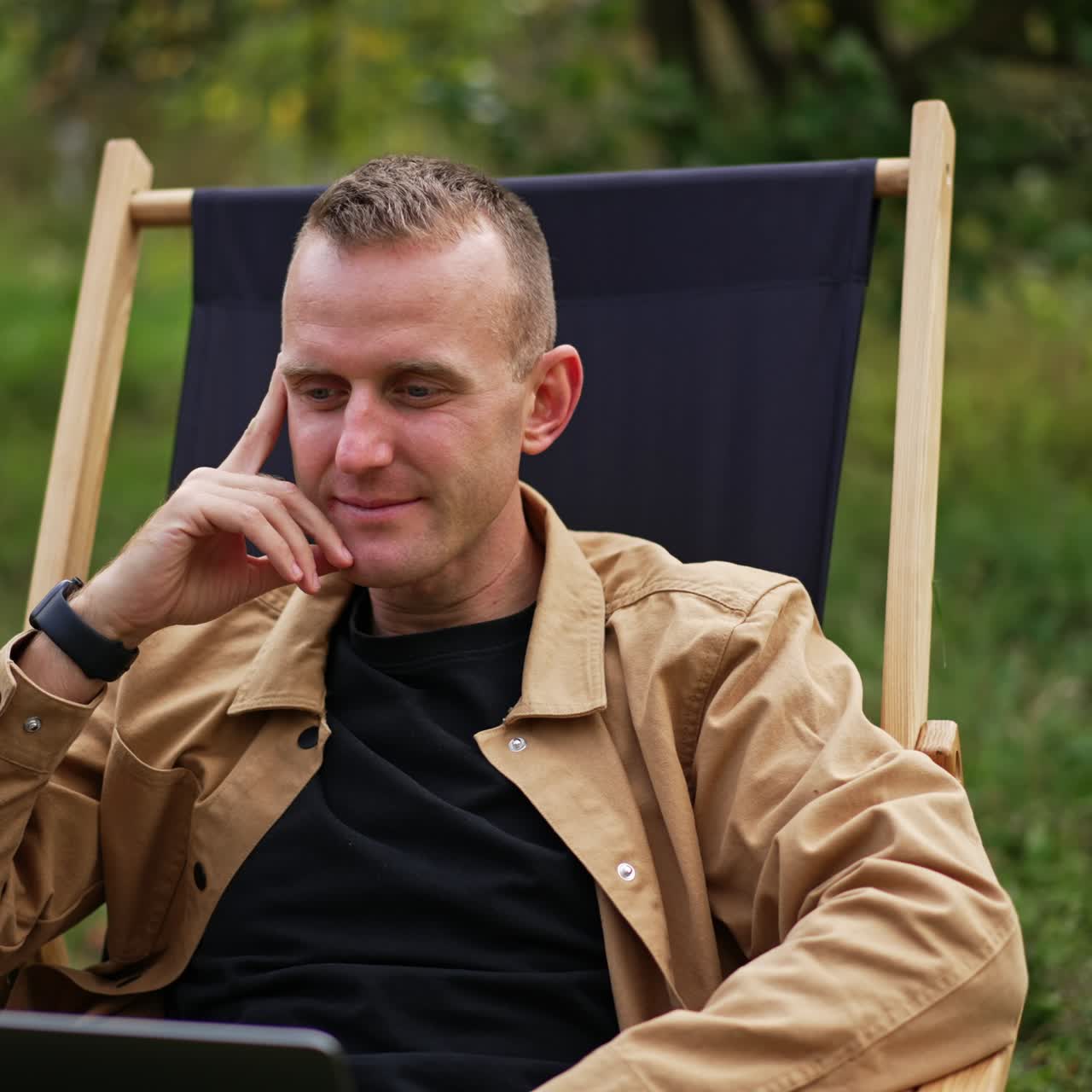 Handsome man with laptop in garden working. Relaxing with notebook