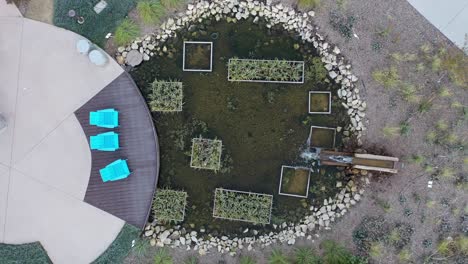 aerial view of a modern urban garden with pond and seating area