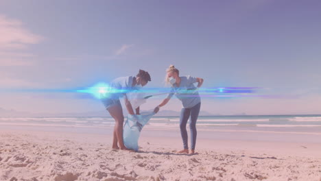 animation of lights over diverse couple in face masks picking up rubbish from beach