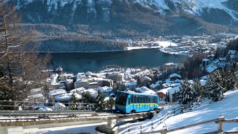 Blaue-Seilbahn-Mit-Stadt,-Häusern,-See,-Bäumen-Und-Bergen-Im-Hintergrund-In-St