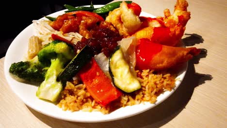plato de comida china apilado con los favoritos populares de bolas de pollo empanadas fritas y camarones con gambas con brotes de frijol de maíz tierno frijoles de soya calabacín en rodajas arroz frito pimientos en rodajas mesa de plato giratorio