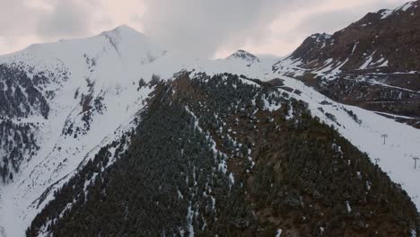 Huge-empty-ski-and-snowboarding-mountain-with-heavy-snow-cover,-drone-aerial