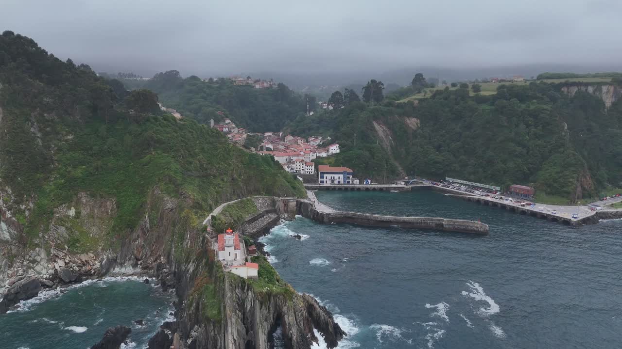 Aerial View of a Coastal Village with a Lighthouse on a Cliff