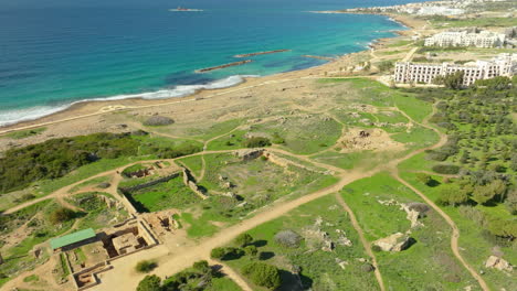 aerial view of tombs of the kings, paphos, with a clear view of the ancient ruins, paths, surrounding greenery, and coastline