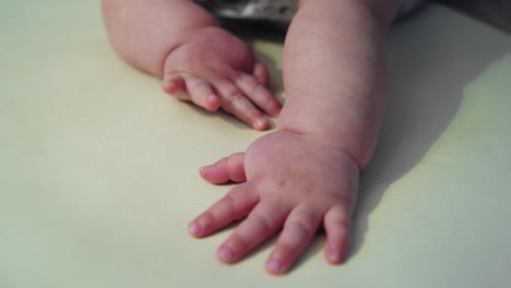 baby hands slapping a play mat while learning how to crawl