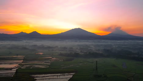 aerial view of rural landscape with mountain range and sunrise sky