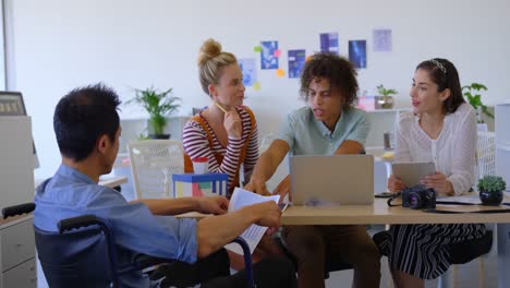 Vista-Trasera-De-Un-Joven-Empresario-Asiático-Sentado-En-Una-Silla-Mientras-Discute-Con-Otros-Negocios