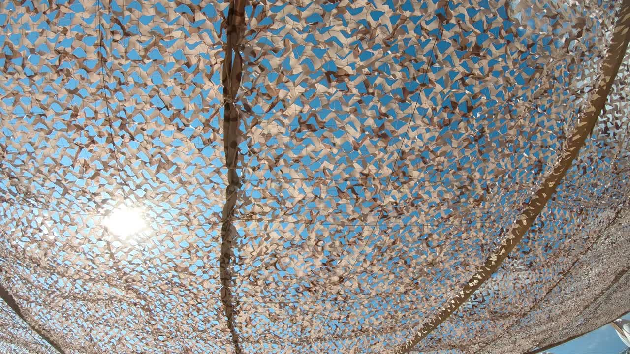 Sun shine through textile sunshade net on summer hot day