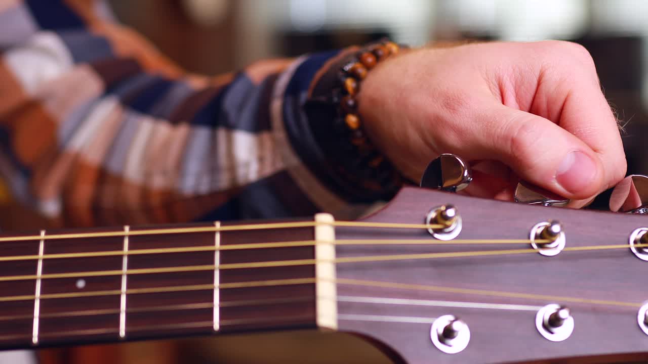 hombre tocando la guitarra en casa aprendiendo y afinando