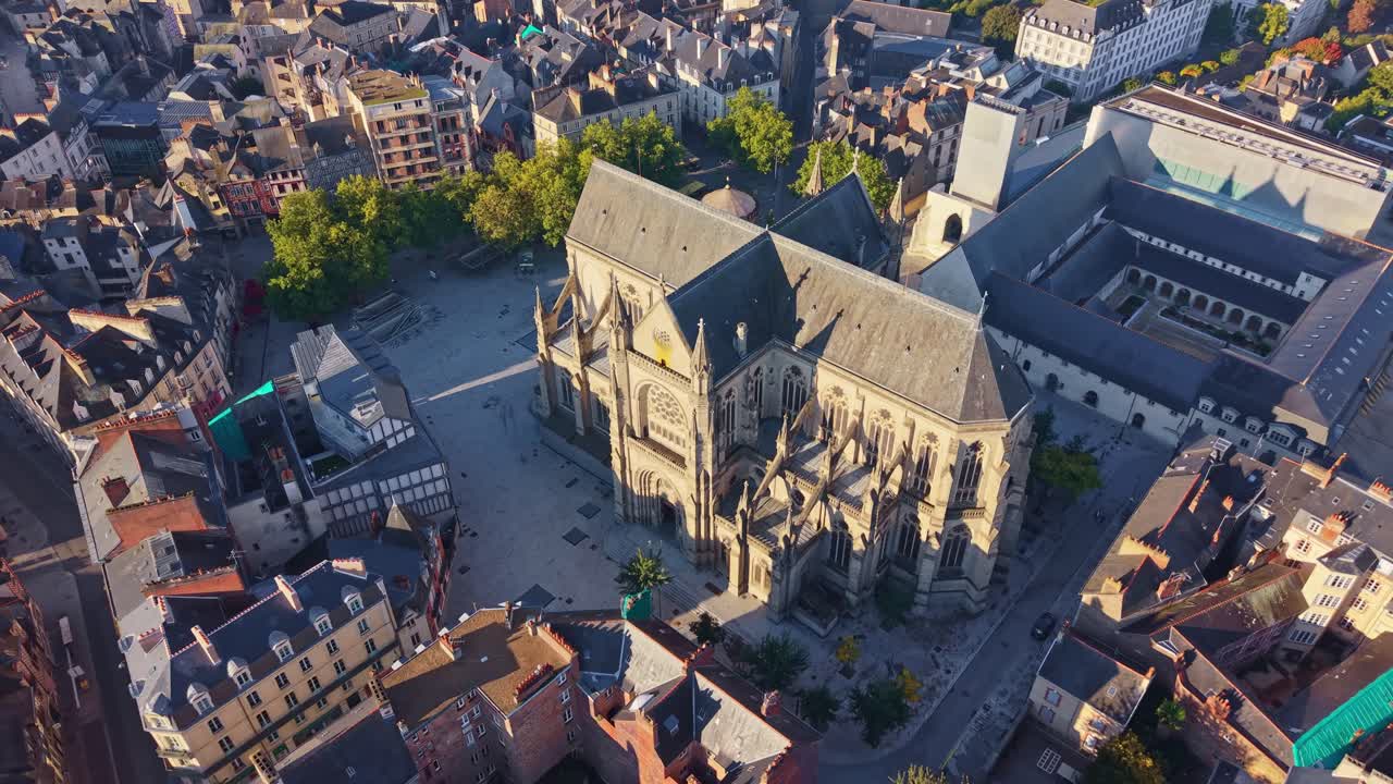 Place Saint-Anne and Saint-Aubin Basilica in Rennes, France at sunrise, Golden light on historic architecture. Aerial drone backward