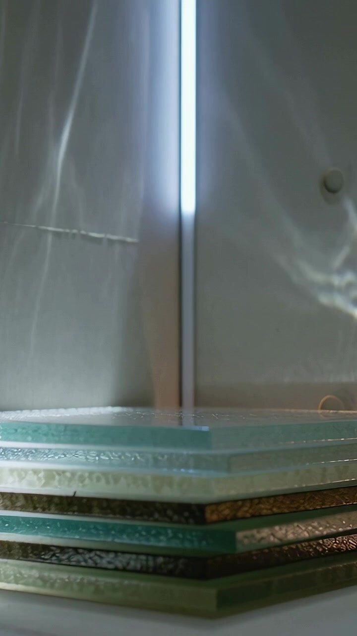 Vertical video: Shifting cam showing glass stack on table, revealing layered edges, LED reflections
