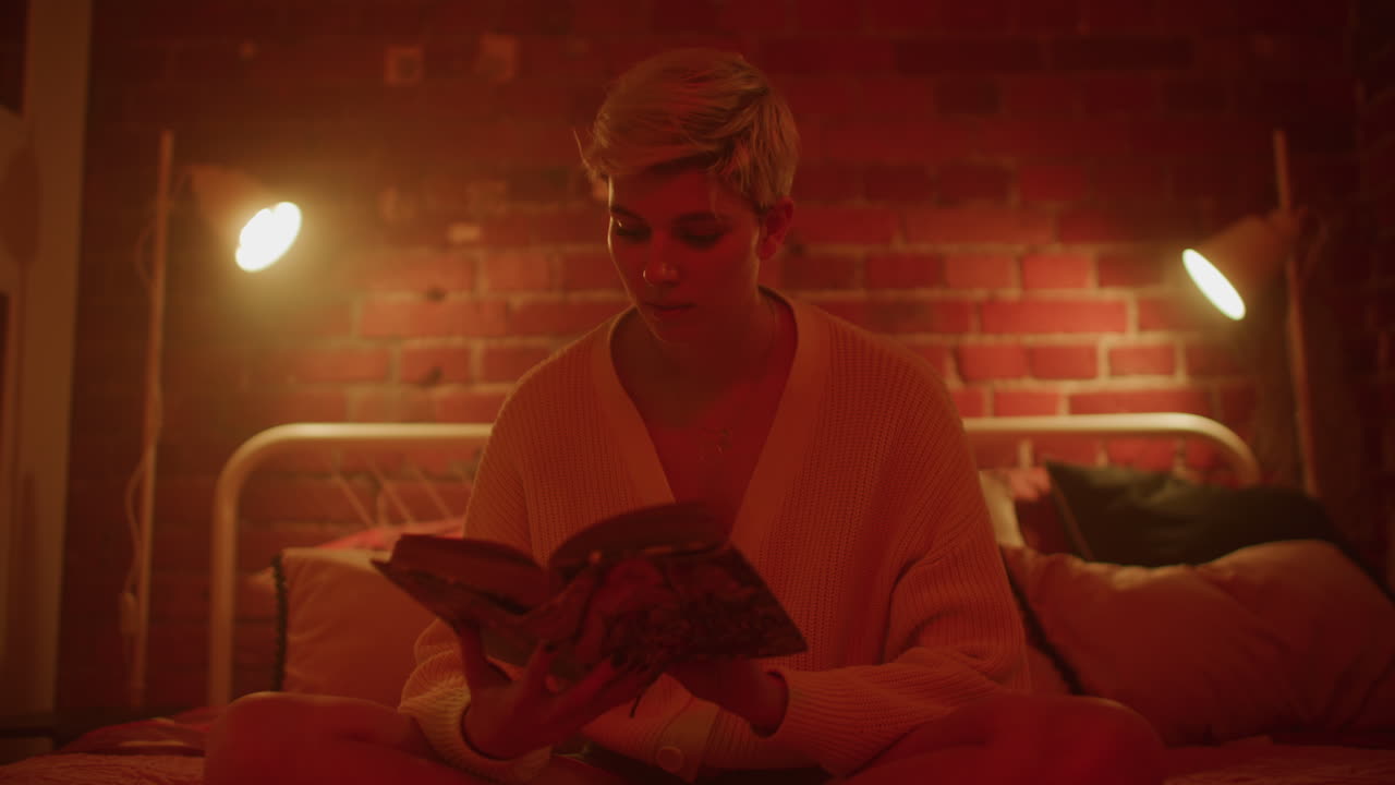 Woman Reading in a Cozy Bedroom at Night