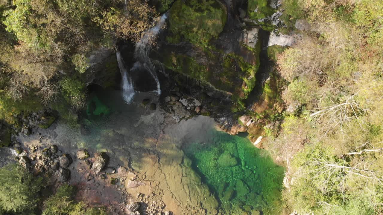 Ripresa aerea della cascata Virje in Slovenia, vista dall'alto di acqua cristallina color smeraldo, in una giornata di sole di fine estate.