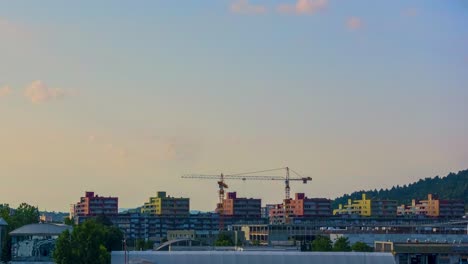 Time-lapse-of-construction-site-with-cranes,-a-shopping-center-in-Ljubljana,-Slovenia,-sunrise-over-urban-area