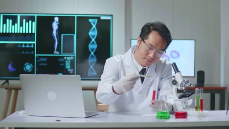 asian scientist researching in the laboratory with test-tube and speaking to the camera