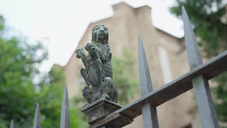 Iron-fence-with-lion-figurine-in-soft-dolly-orbit-shot