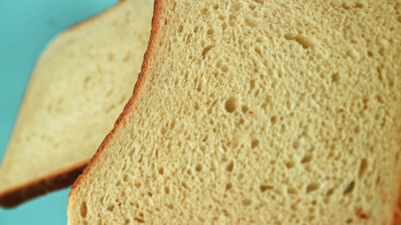Slices of White Bread Falling in Slow Motion on Blue Background