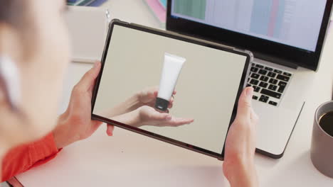 caucasian woman at desk using tablet, shopping online for beauty products, slow motion