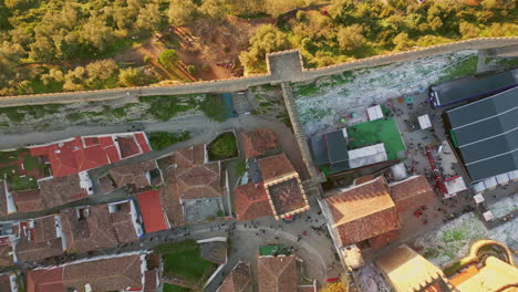 aerial view village rooftops with red tiles sunny evening. castle stone wall