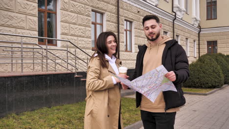 una pareja caucásica chequeando el mapa para obtener direcciones en la calle.