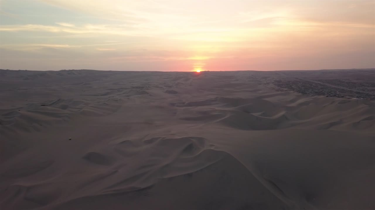 toma aérea 4k de las dunas de arena al atardecer en huacachina, perú