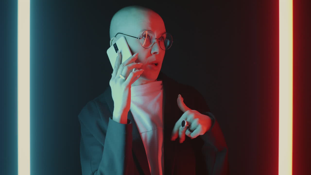 Stylish Bald Woman on a Phone Call in Neon Lighting