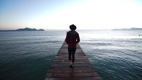 guy walks down a bridgte to the sea of mallorca