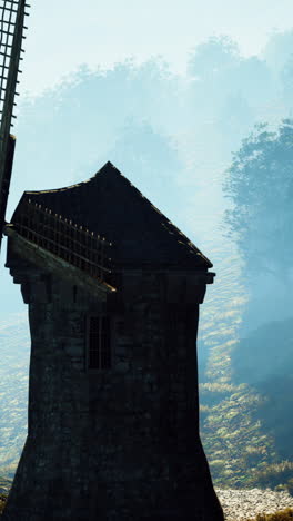 a stone windmill on a foggy hillside