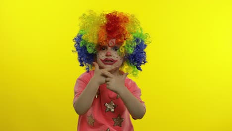 Little-child-girl-clown-in-wig-making-silly-faces.-Singing,-making-shot-signs-from-hands.-Halloween