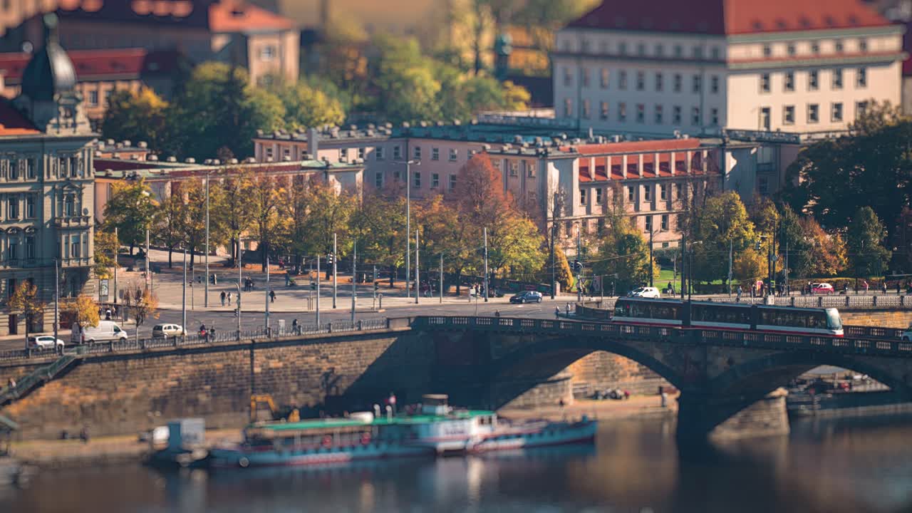 Busy traffic in Prague on the Vltava River embankment and one of its' bridges