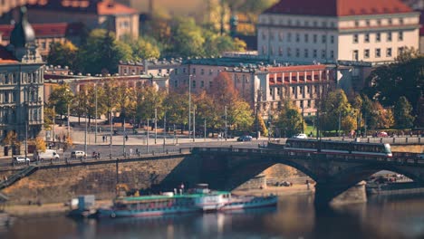 busy traffic in prague on the vltava river embankment and one of its' bridges