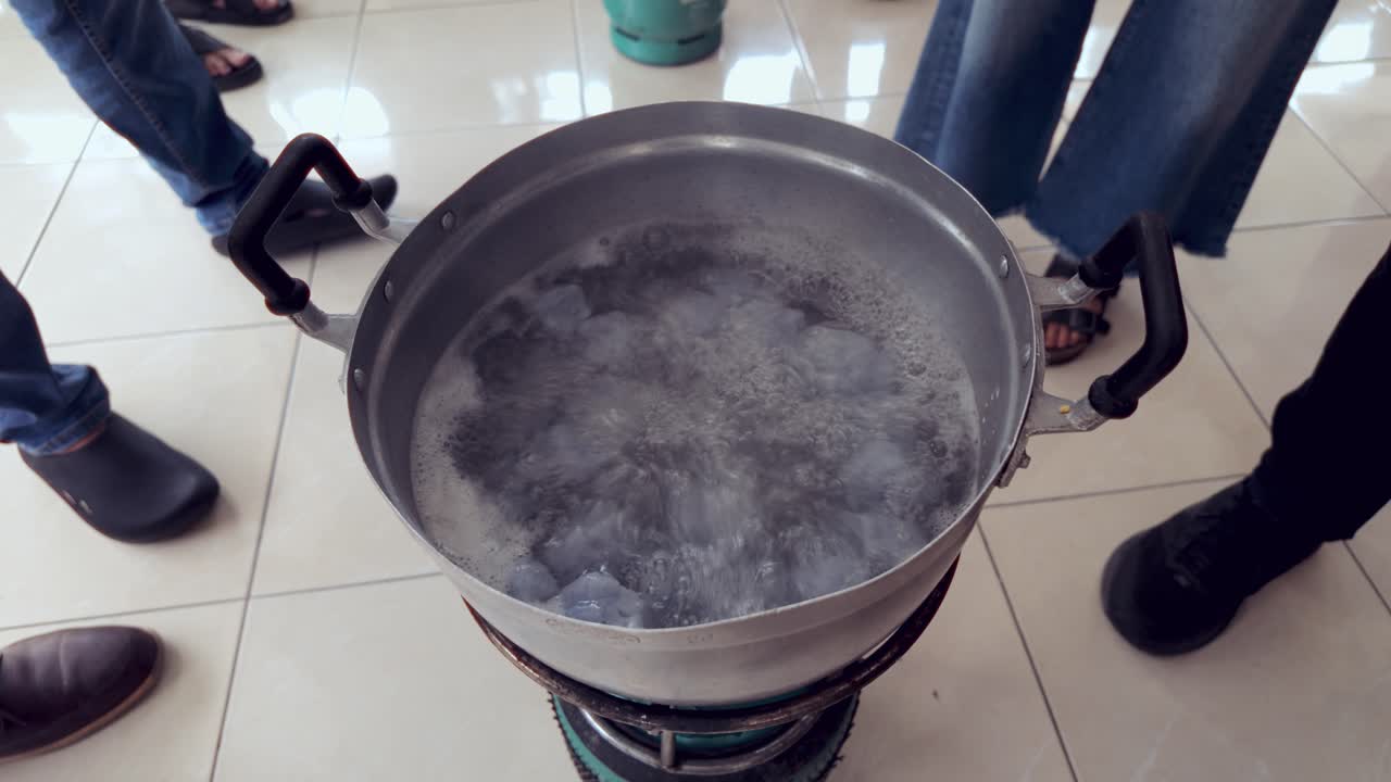 Part 5 of a 6-part series showing the full traditional process of making Khanom Tom, a Thai coconut dessert. Khanom Tom balls boil until they float, signaling they are ready.