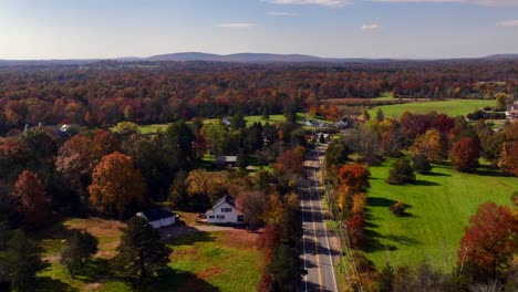 A-high-angle-aerial-view-over-the-quiet-countryside-of-New-Jersey-with-colorful-trees-and-large-green-fields-all-around-on-a-sunny-day-in-autumn