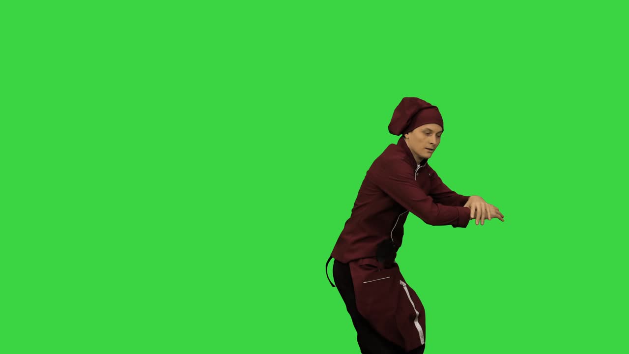 Cuoco in uniforme rossa che fa break dance con una spatola su sfondo verde, Green Screen, Chroma Key