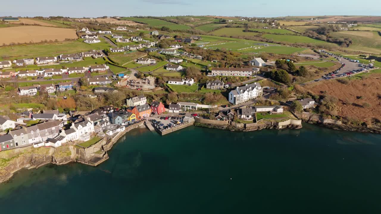 Calm sunny day with green blue waters and colorful village houses, coastal Summercove, Kinsale, Ireland from above